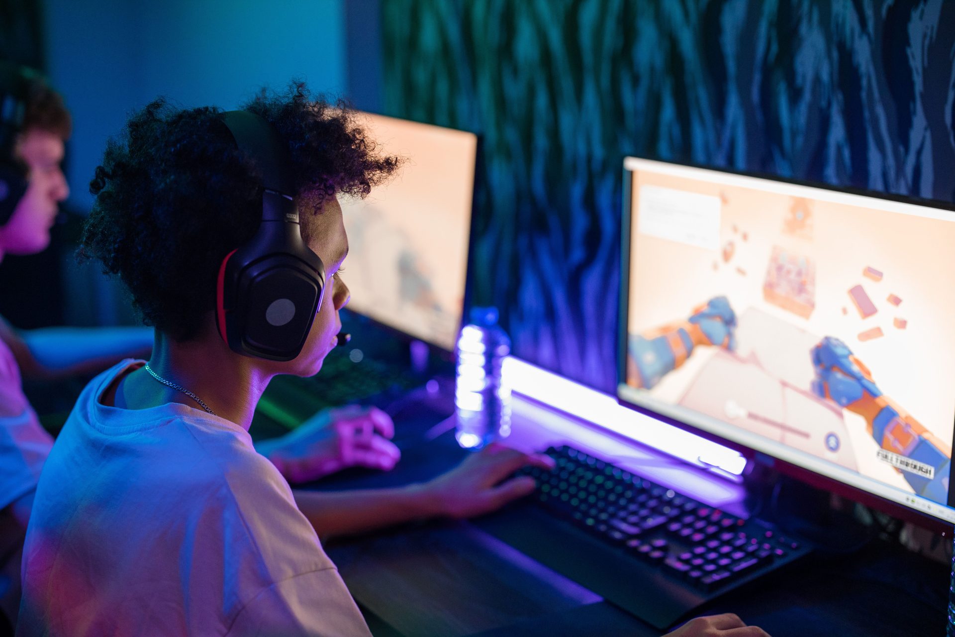 Players at a long wooden row of PC stations inside the BLOOP computer club